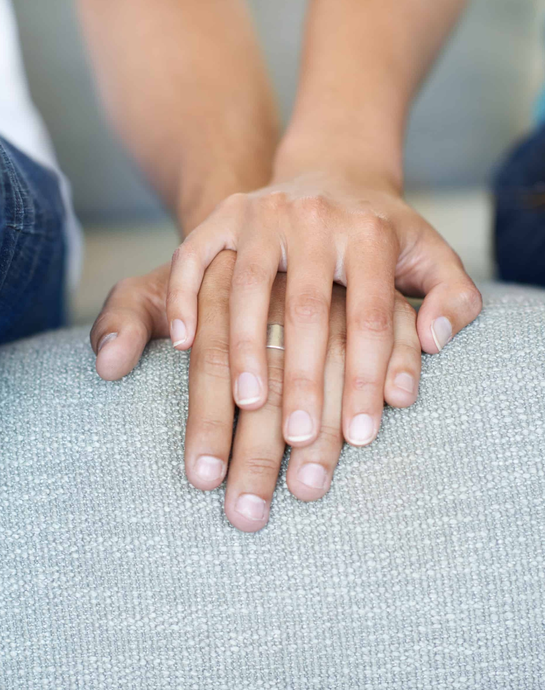 Couple sitting together with hands gently resting in between