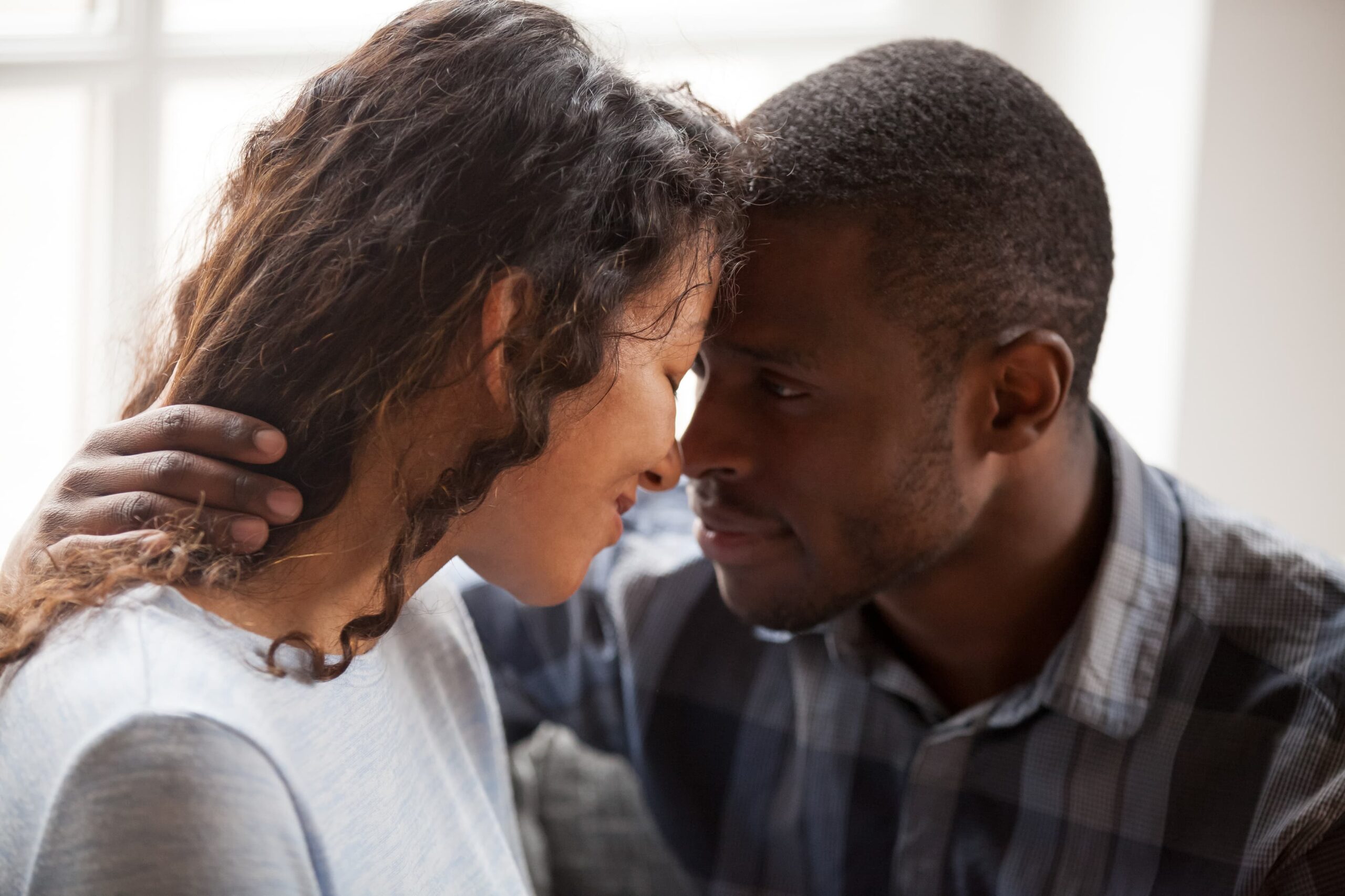 Couple in intimate moment with foreheads touching showing deep emotional connection