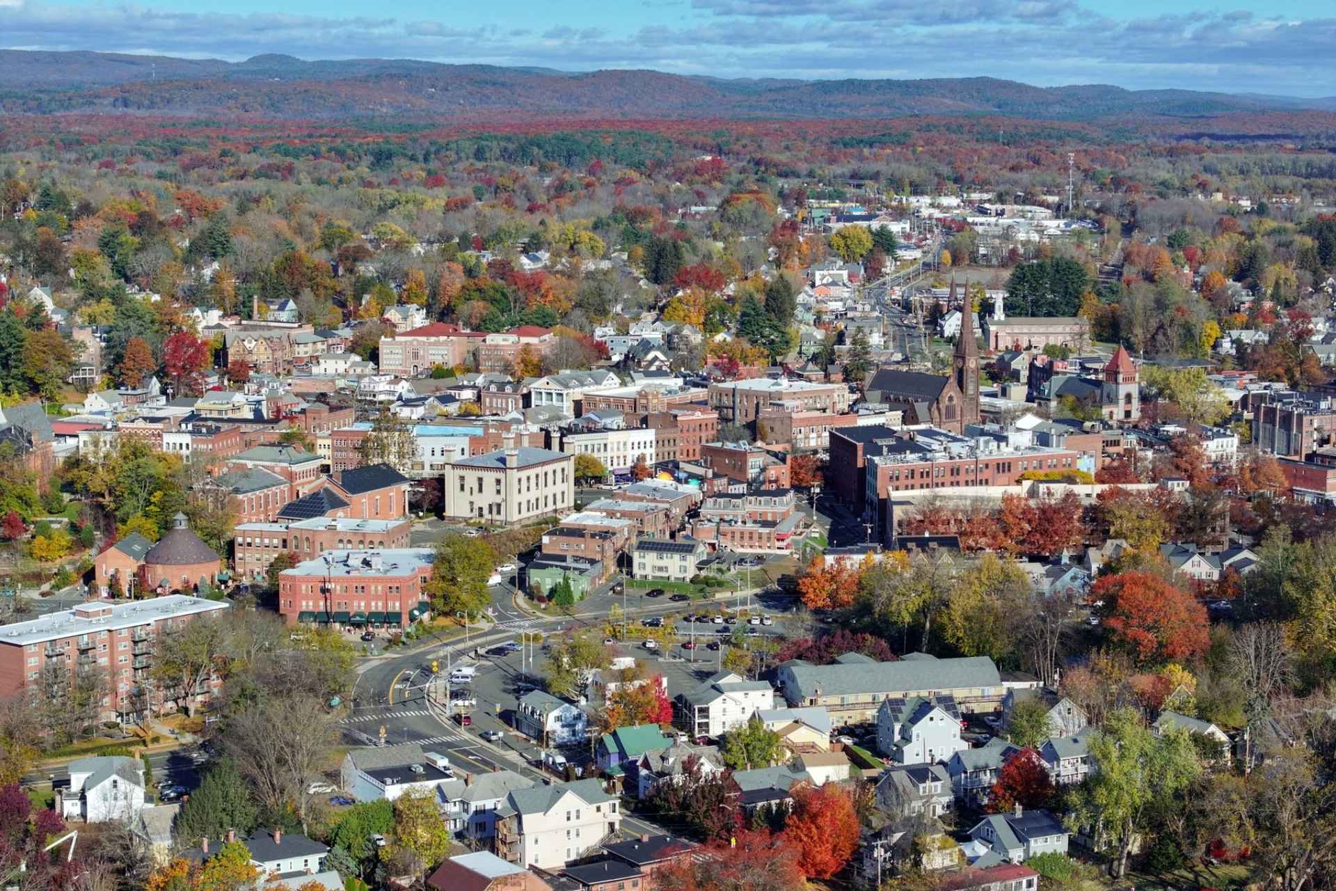 Aerial view of downtown Northampton, Massachusetts, in autumn, with the hills of the Pioneer Valley beyond.